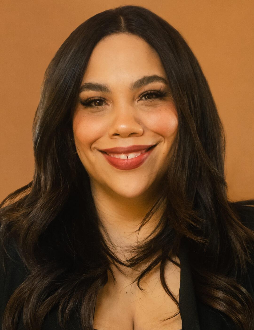 Studio portrait of Angela Ubias against brown background Mobile
