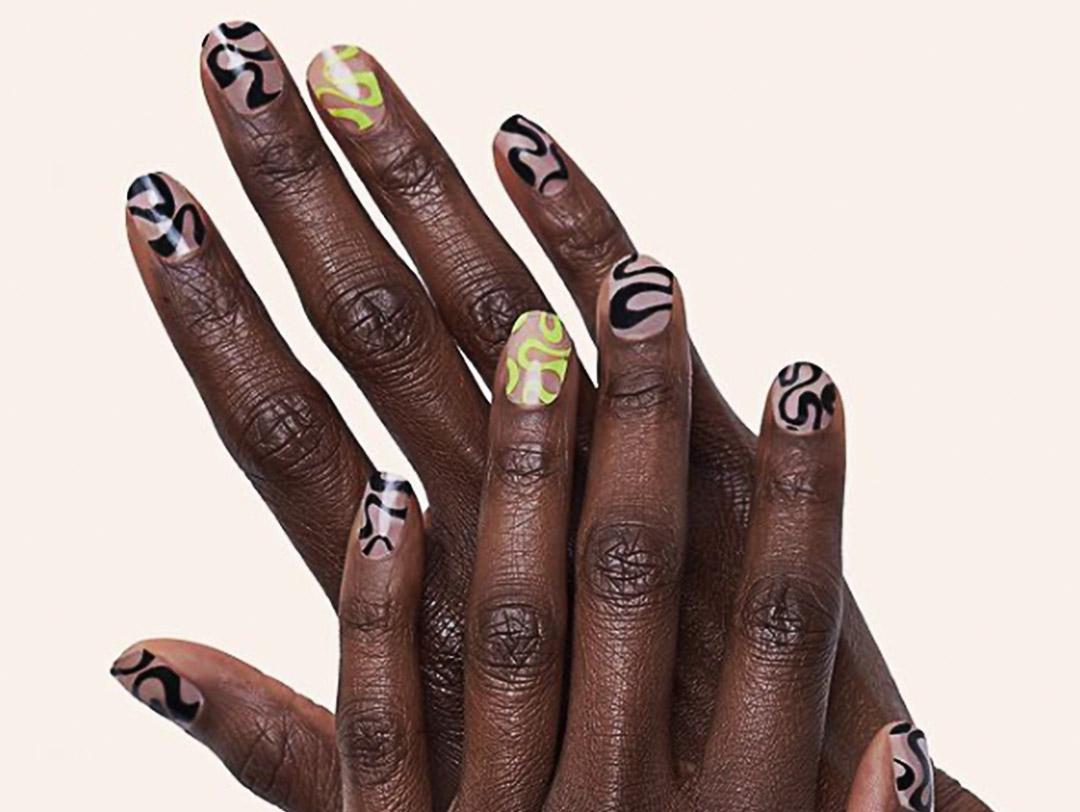 A photo of hands with black and light green nail designs