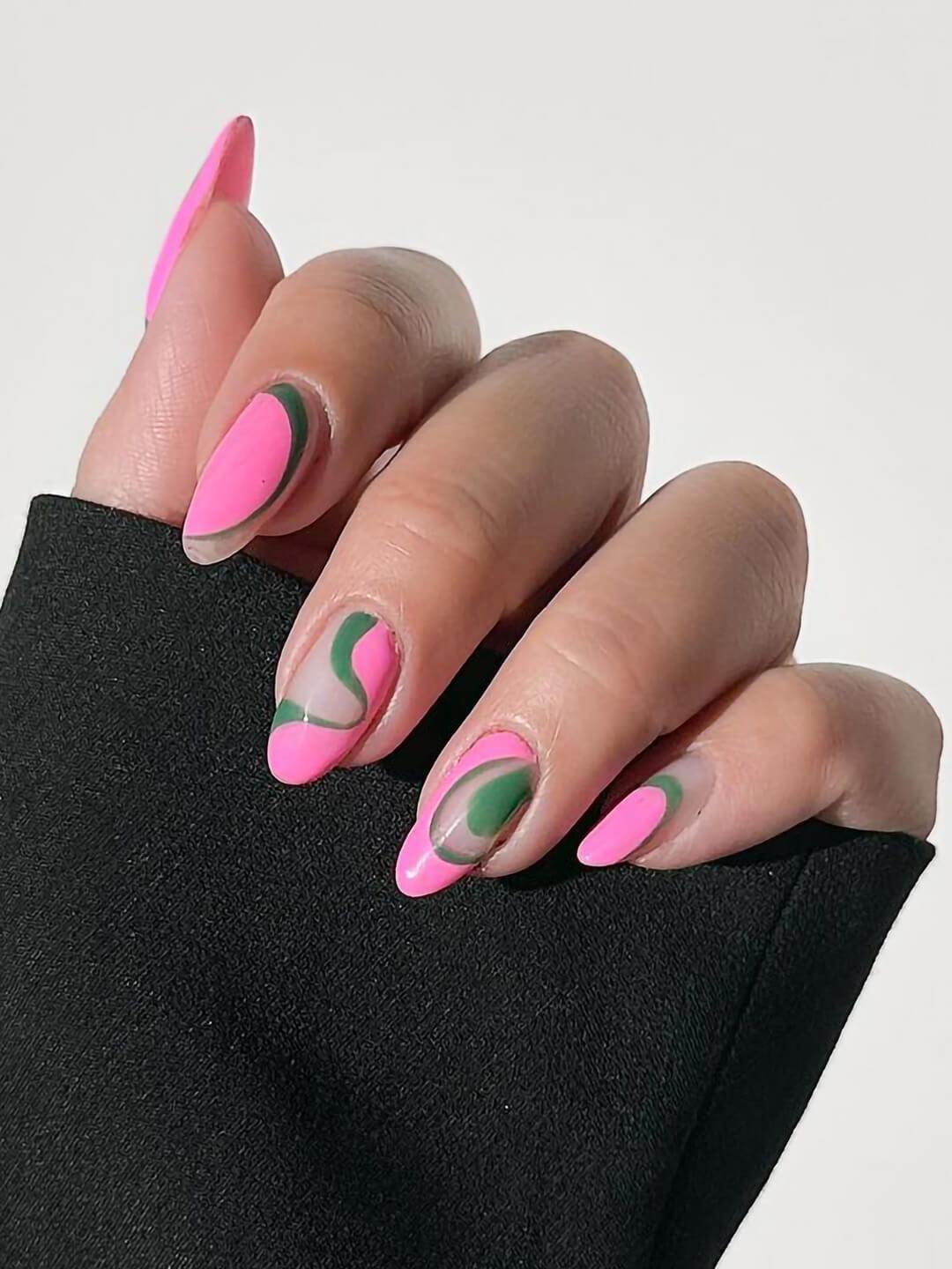 Close-up of a woman's hand with pink and green swirly nail art
